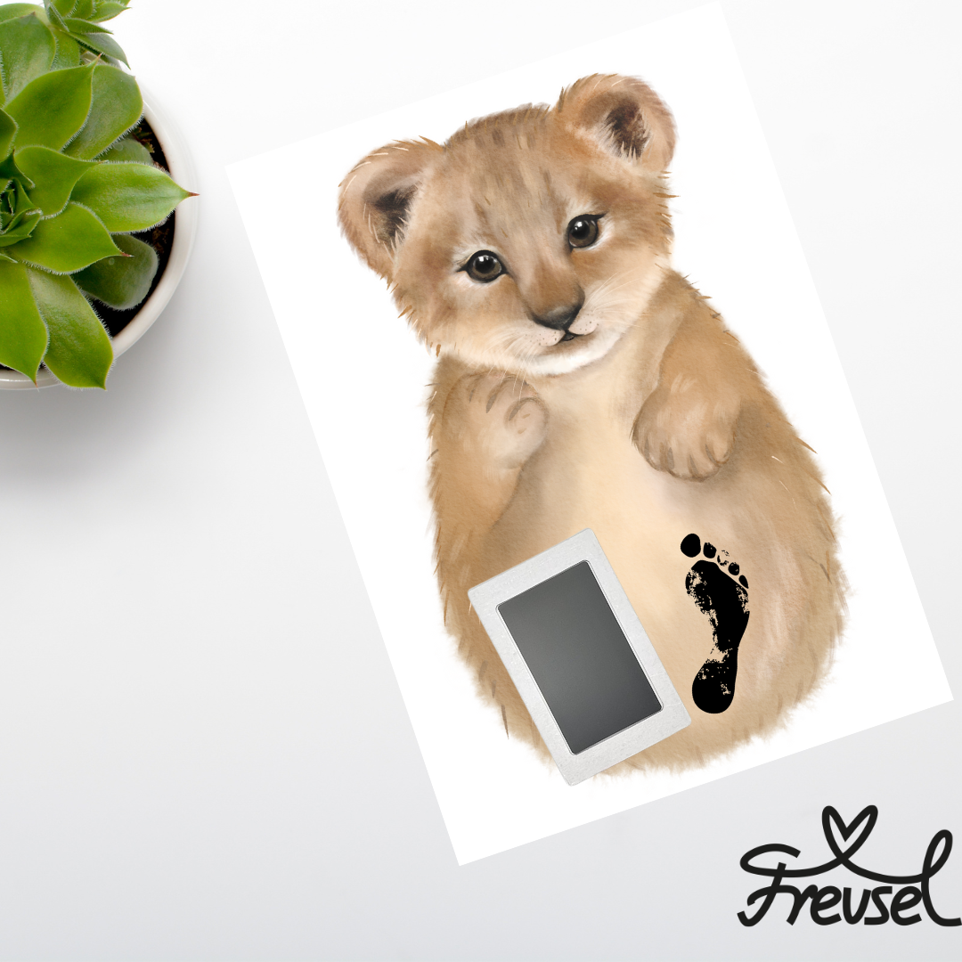 Anleitungsschritte des Freusel-Löwen-Motivs mit Freusel-Logo. Fertiges personalisiertes Bild liegt auf Tisch neben einer Pflanze mit beiden Baby-Fußabdrücken darauf. 
