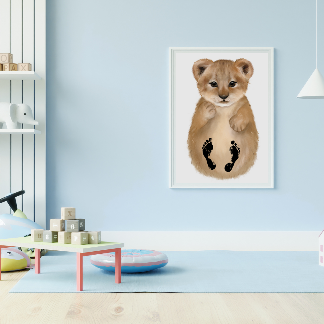 Individualisiertes Bild vom Löwen mit Baby-Fußabdrücken hängt im weißen Bilderrahmen im Kinderzimmer auf.